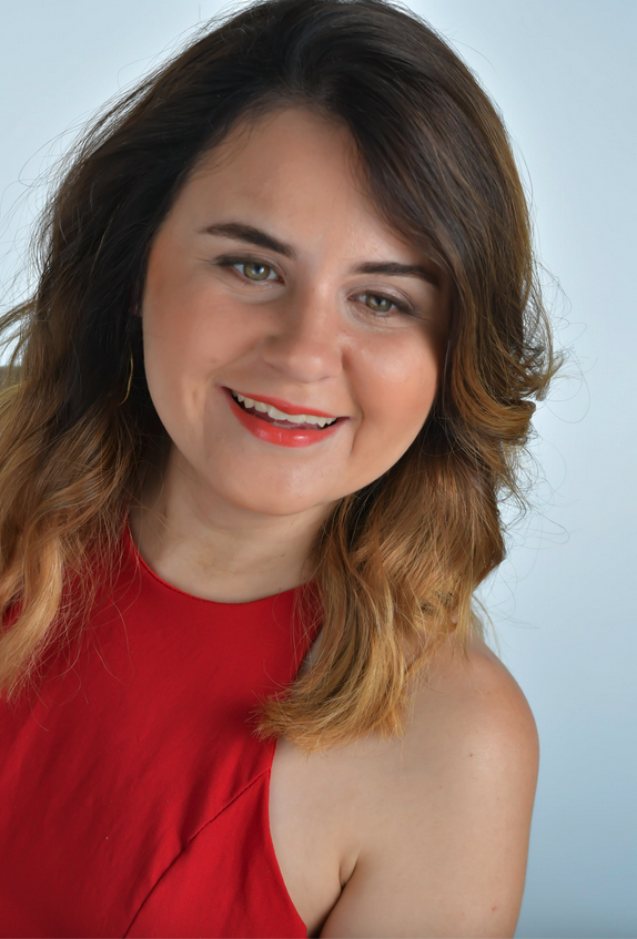 A white woman with long hair wearing a red dress.