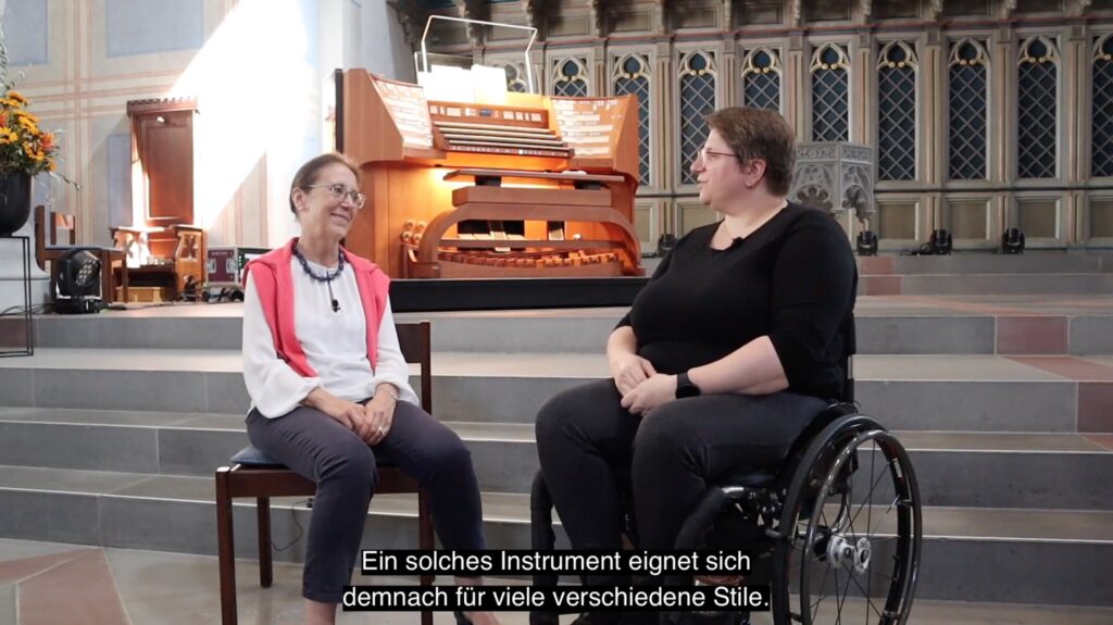 Screenshot of a YouTube interview of Sophie-Véronique Cauchefer-Choplin by Diane, with a German subtitle of the captured moment.