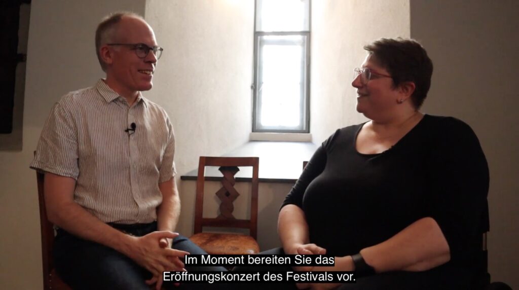 Screenshot of a YouTube interview of Bernhard Ruchti by Diane, with a German subtitle of the captured moment.